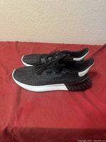 Left side profile of both sneakers showing uppers, midsoles, heel