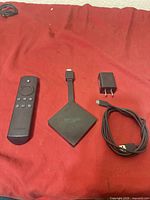 Fire TV unit, voice remote, power adapter, USB cable laid out