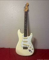 Full front view of cream Fender Squier Stratocaster guitar
