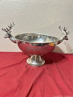 Full view of punch bowl showing stag head handles and pedestal base