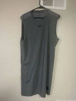 Full front view of gray Nike sleeveless top on hanger