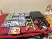 Overview showing PS4 Pro console, controllers, charging dock, cables and game cases