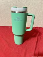 Full side view of jade green Stanley tumbler with handle