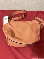 Front view of Coach light coral Dufflette with tag attached