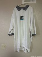 Front view of white Tri-Mountain polo with tag attached