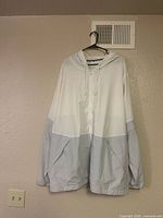 Front view of Under Armour UA Squad jacket, showing color-block design and hood