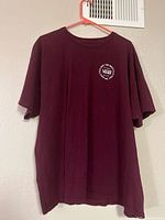 Front view of maroon Vans T-shirt on hanger