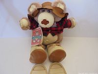 Front view of Furskins bear seated with detached boots in foreground