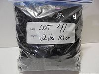 Sealed zipper bag labelled 2 lbs 10 oz filled with black LEGO pieces