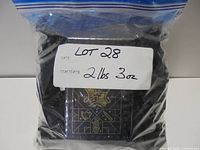 Bag labelled Lot 28 2 lbs 3 oz showing printed Hogwarts-style tile