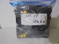 Bag of black LEGO parts with label showing lot number