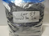 Front view of sealed bag labeled 2 lbs 1 oz filled with dark bluish grey LEGO parts