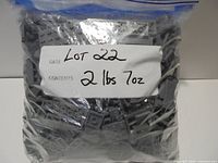 Front view of sealed bag filled with dark bluish grey LEGO elements labelled 2 lbs 7 oz