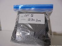 Bagged LEGO pieces with handwritten label showing lot number and weight