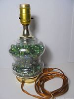 Full view of glass lamp showing marbles, base, socket and cord