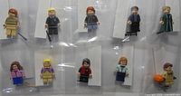 Group shot of ten sleeved minifigures in two rows with accessories visible
