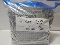 Bag of light bluish gray LEGO pieces labeled with lot info