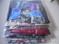 Stack of twelve bagged graphic T-shirts