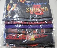 Stack of folded graphic T-shirts showing Golden Axe and Revenge of Shinobi prints