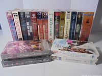 Group shot of 18 sealed VHS tapes, showing spines and two stacks lying flat