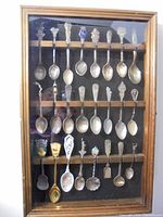 framed display containing 24 spoons, full view