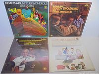 Group shot of four sealed LPs showing covers