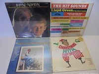 Group shot of four sealed LP albums showing all cover fronts