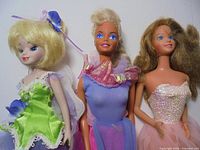 Three dolls side by side showing size comparison and outfits