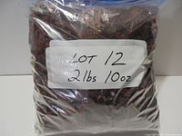Full bag of reddish brown LEGO pieces with label indicating weight
