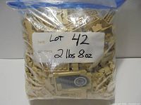 Front of sealed bag showing tan LEGO bricks and weight label