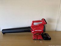 Leaf blower with batteries and charger on tabletop