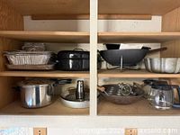 Overall view of cabinet shelves showing all cookware, coffee carafe and trays