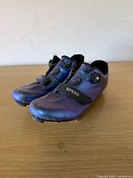 Three-quarter front view of both shoes showing uppers, closures and color