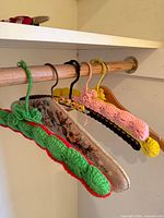 Five assorted vintage padded hangers on closet rod