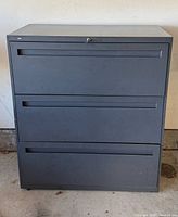 Front view of gray 3-drawer metal lateral filing cabinet