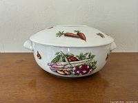 Full view of casserole with lid showing vegetable motif and side handles
