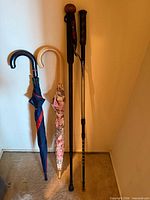 Four long items leaning against wall on carpeted floor