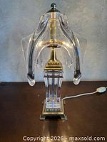 Full view of lamp showing crystal column base, brass foot, arms and finial
