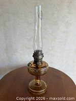 Full view of amber Aladdin Washington Drape oil lamp with chimney