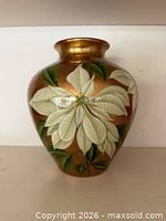 Front view of metallic gold vase with white poinsettia design
