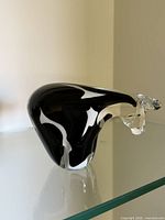 Side profile of black and white glass cow showing clear head and tail