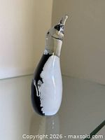 Front profile of the black, white and clear glass penguin