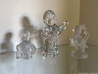 Front view of three crystal figurines on shelf