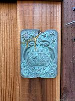 Front view of verdigris garden wall plaque mounted on wood