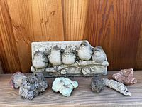 Front view of Carruth baby birds concrete plaque with five assorted rocks beneath