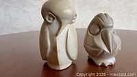 Front view of two carved stone owl figurines on table