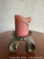 Holder with pink pillar candle on top showing overall design