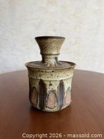 Front view of stoneware jar with lid in place