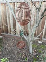 Full view of three-disc wind spinner hanging outdoors