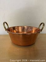 Front angled view of copper basin showing brass handles and exterior patina
